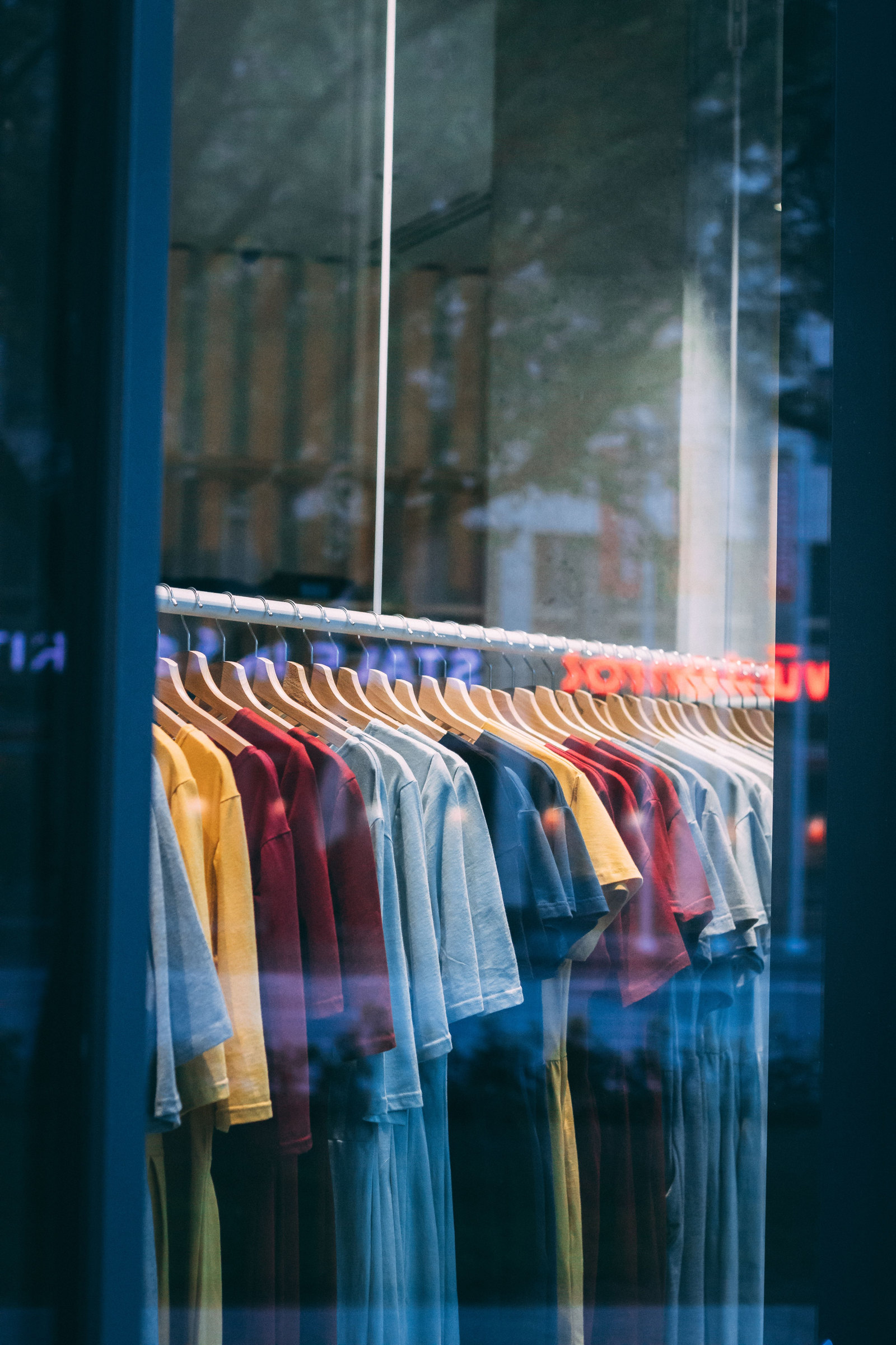 Colourful clothes on hangers in a shop window